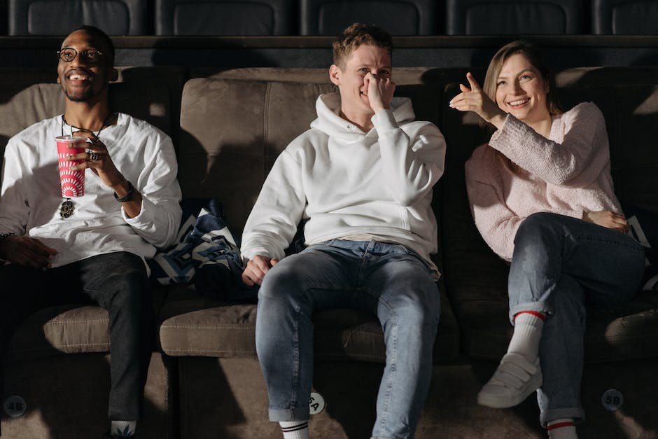 Image of people watching a movie in a cinema, with an advertisement displayed on the screen.